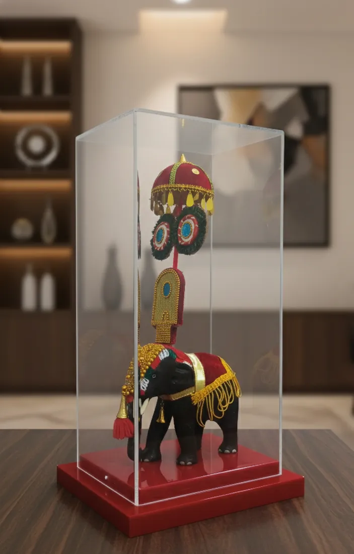 Decorated elephant figure in a tall acrylic case on a red base