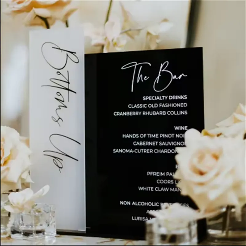 Frosted and black acrylic bar menu signs with white script lettering at a wedding
